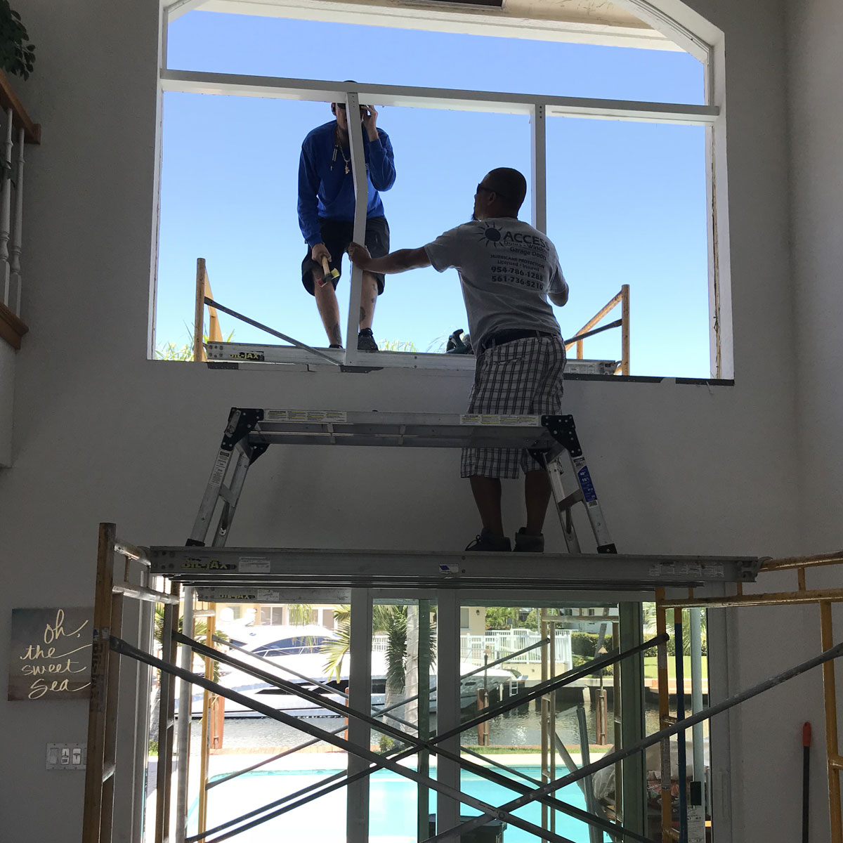 Crew on a lift installing a high-ceiling window