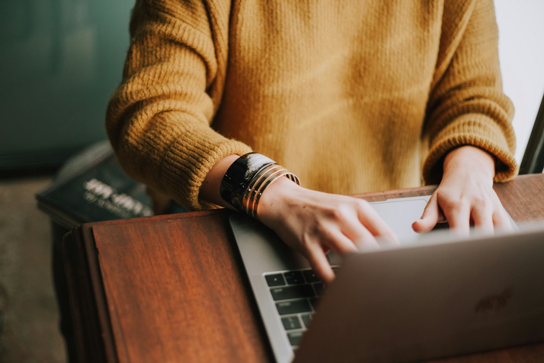 homeowner researching window companies on laptop - home window replacement companies near me