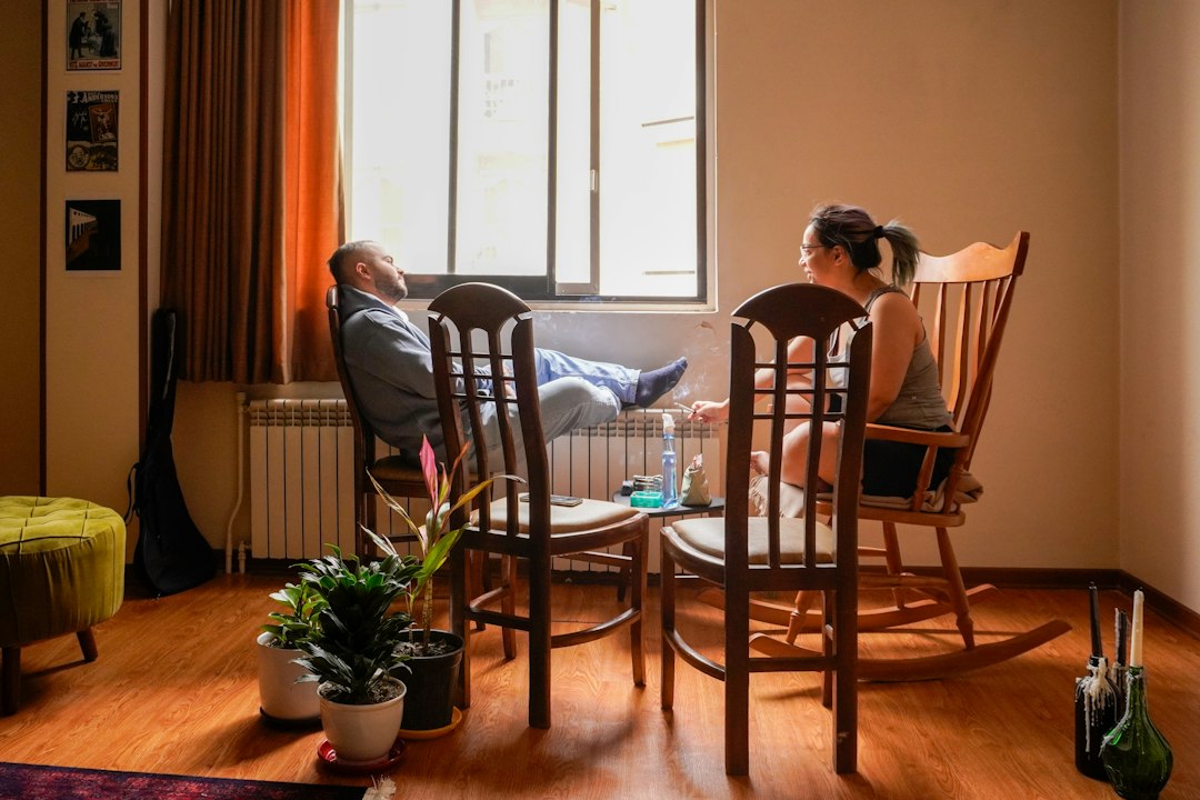 A family relaxing peacefully in their quiet living room, safe behind an impact door - door impact
