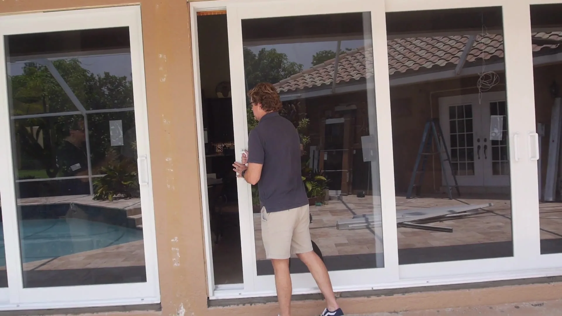 Our installer at a set of new sliding glass doors beside a pool